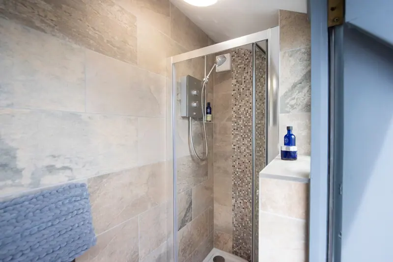 The tiled shower room, with a glass-screened shower cubicle